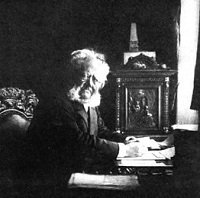 Henrik Ibsen in einem Zimmer am Schreibtisch sitzend