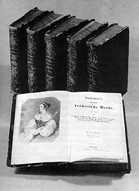 Shakespeare-Ausgabe von 1858, aufgeklappt, mit weiteren Büchern in einer Reihe stehend im Hintergrund